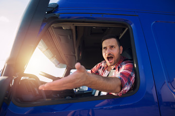 Angry and nervous truck driver yelling at someone in traffic. Difficulties on the road.