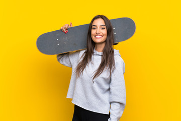 Young skater woman over isolated yellow background © luismolinero
