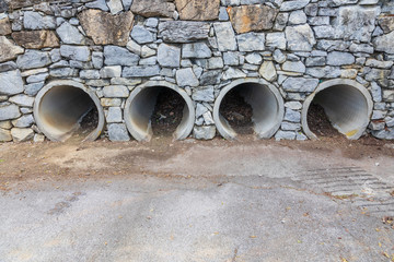 Four drainage culverts in rock wall