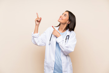 Young doctor woman over isolated background pointing with the index finger a great idea