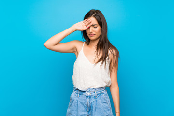 Young woman over isolated blue background with tired and sick expression