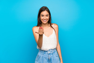 Young woman over isolated blue background inviting to come with hand. Happy that you came - obrazy, fototapety, plakaty