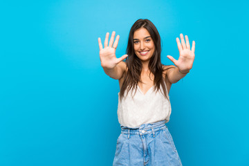 Young woman over isolated blue background counting ten with fingers