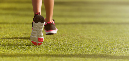Running children detail on sport shoes running along green grass - Powered by Adobe
