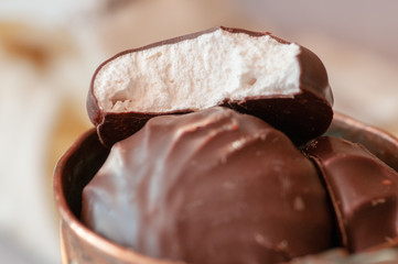 Chocolate marshmallows in mint cup. on a wooden table