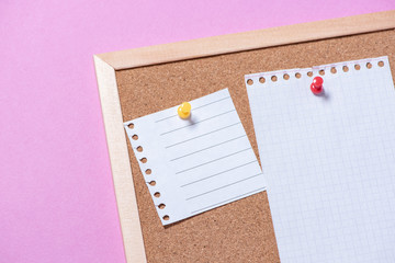 Corkboard for notes with empty sheets on buttons on a pink background