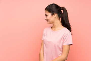 Teenager girl over isolated pink background standing and looking to the side