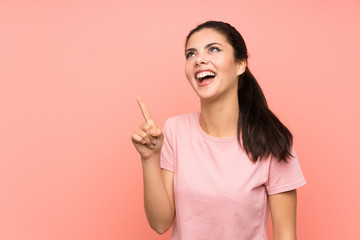 Teenager girl over isolated pink background touching on transparent screen