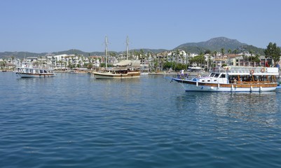 Fototapeta na wymiar View of the embankment of the city of Marmaris from the sea. City-port and resort in Turkey. Sandy beaches, mountain landscapes.