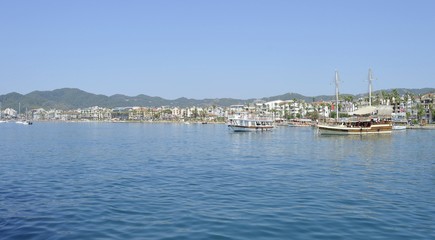 Fototapeta premium View of the embankment of the city of Marmaris from the sea. City-port and resort in Turkey. Sandy beaches, mountain landscapes.