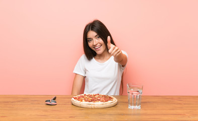Young woman with a pizza with thumbs up because something good has happened