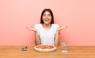 Young woman with a pizza with shocked facial expression