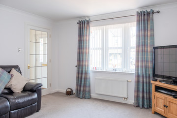 Two Walled View of Modern Lounge in Scottish Housing Developement with Decorated Walls french door...