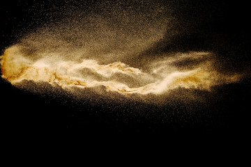 Naklejka na ściany i meble Dry river sand explosion isolated on black background. Abstract sand cloud.Brown colored sand splash against dark background.