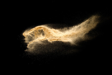 Dry river sand explosion isolated on black background. Abstract sand cloud.Brown colored sand...