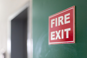 Emergency exit sign on hotel wall. Fire exit sign mounted on the green wall of the corridor.
