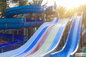Water slide for summer fun. Three large water slides different colors near the pool