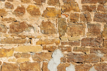 Schöne helle Sandsteinmauer von einem alten Bauernhof ohne Bewuchs mit vielen unterschiedlich großen Fugen und verschieden großen Steinen und teilweise mit Zement ausgebessert