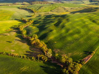 Aerial drone landscape of famous Tuscany hills, Italy spring fields sunset Asciano Siena Firenze