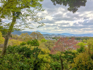 Beautiful panorama view of colorful trees and small town in Kyoto from mountain with cloudy sky, Japan
