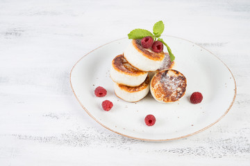 Delicious cheesecakes pancakes, decorated with fresh berries and mint. Horizontal orientation.