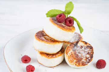 Delicious cheesecakes pancakes, decorated with fresh berries and mint. Horizontal orientation.