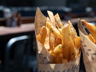 Gourmet french fries deep fried and piled into steel cup with wrapper