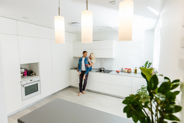 Portrait of a smiling loving couple cooking salad together while standing on a kitchen at home