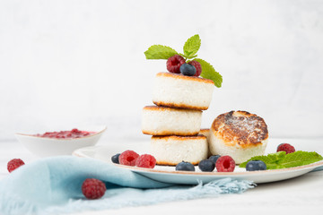 Delicious cheesecakes pancakes, decorated with fresh berries and mint. Horizontal orientation.