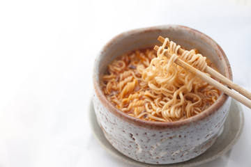 Hot and Spicy instant noodle in clay bowl on white background.