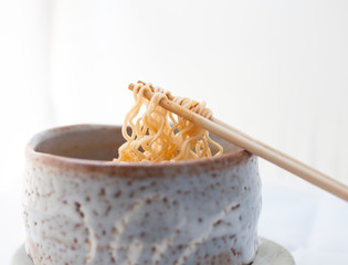Closeup hot and spicy instant noodle in clay bowl.