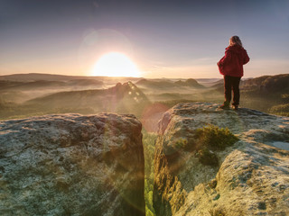 Woman in outdoor clothes  enjoy view at summit in mountains.