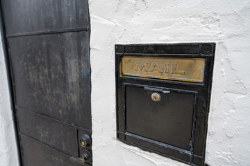 Black mail slot and lock outside of door of building