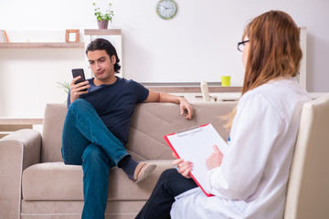 Young male patient discussing with female psychologist personal