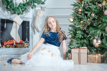 portrait of a girl in Christmas decorations. child enjoy the holiday near Christmas tree. 