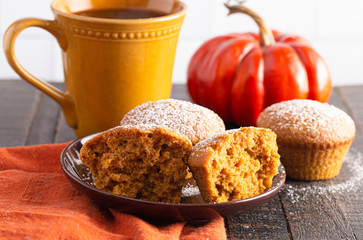 Pumpkin Spice Muffins Topped with Powdered Sugar on a Wooden Table