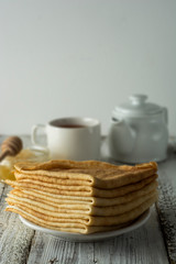 Fototapeta na wymiar Pancakes. Thin pancakes. Russian bliny. Healthy tasty breakfast - pancakes, a cup of tea and honey. Copy space.