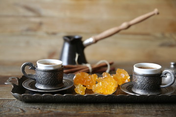 a cup of oriental coffee in the national style with cezve and sweets on a wooden rustic table with copy space for text. Gastronomic Travel.