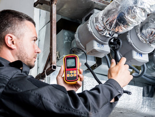 Technician use hand-held anemometer measuring air flowing measurement, wind speed and pressure.