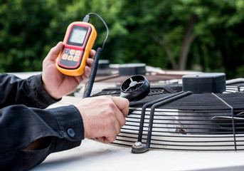 Technician use hand-held anemometer measuring air flowing measurement, wind speed and pressure. - obrazy, fototapety, plakaty