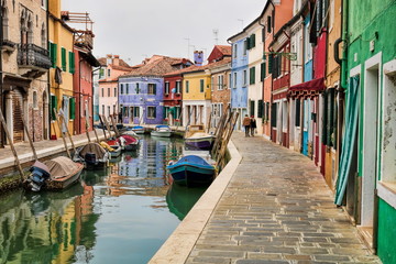 Fototapeta na wymiar idyllischer kanal mit booten und bunten häusern in burano, italien