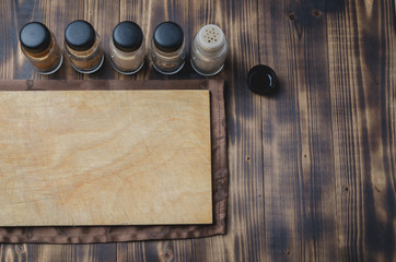 Various spices, cutting board and cooking utensils on wooden background. Top view with space