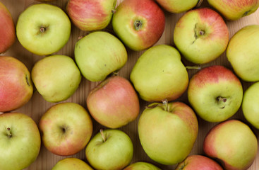 Ripe apples on a wooden background. A lot of apples as a background.