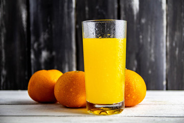 oranges and orange juice on wooden background