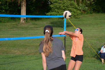Girl setting volleyball to her partner outdoors