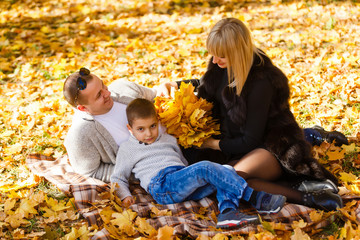 The family walks in the park in autumn