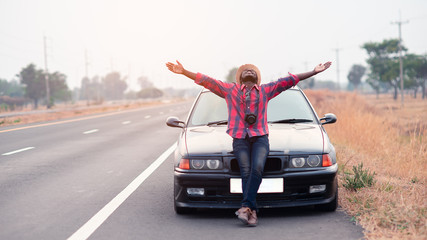 Freedom African traveler man holding camera with sitting on the car