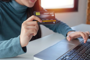 young woman entering security code with laptop computer and paying credit card on desk at home office, internet network technology, electronic online booking, payment and shopping online concept