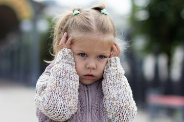 Child holding her head by hands feeling stress