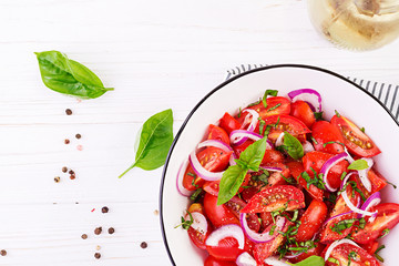 Tomato salad with basil and red onions. Homemade food.  Concept healthy meal. Vegan cuisine. Top view